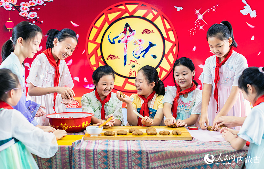 呼和浩特市玉泉區(qū)恒昌店巷小學(xué)學(xué)生在學(xué)習(xí)制作手工月餅。丁根厚攝