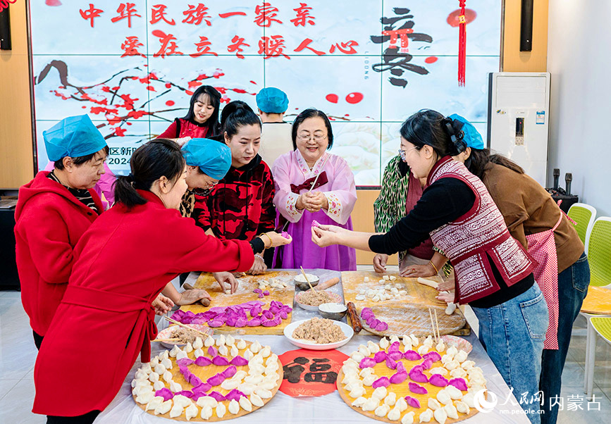 11月7日，工作人員和居民在呼和浩特市玉泉區(qū)清泉街社區(qū)迎立冬主題活動現(xiàn)場包餃子。丁根厚攝