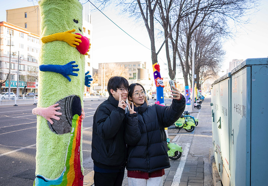 12月9日，市民在呼和浩特市玉泉區(qū)凱德廣場打卡“穿”毛衣的大樹。丁根厚攝