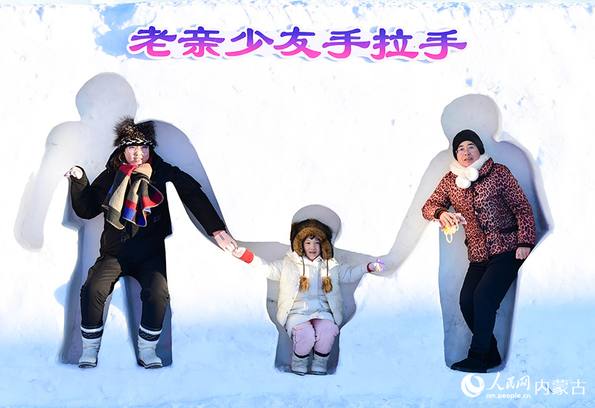 12月12日，游客在滿洲里“冰雪童謠”主題樂園與一處雪雕墻互動。王正攝