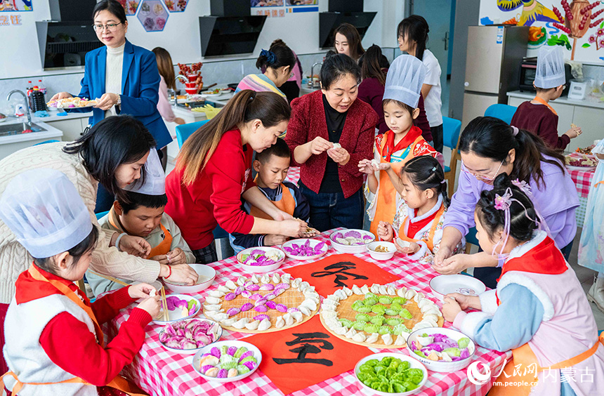 呼和浩特市玉泉區(qū)南柴火市街小學(xué)學(xué)生和家長用包好的餃子擺出“冬至”字樣。丁根厚攝
