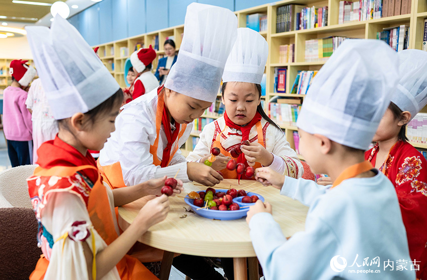 呼和浩特市玉泉區(qū)南柴火市街小學(xué)學(xué)生在學(xué)習(xí)制作糖葫蘆。丁根厚攝