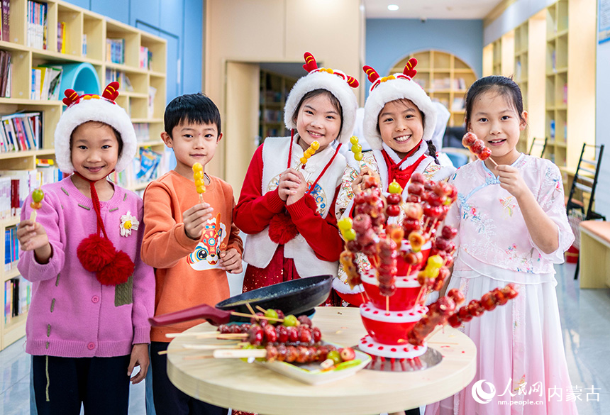呼和浩特市玉泉區(qū)南柴火市街小學(xué)學(xué)生展示自己制作的糖葫蘆。丁根厚攝