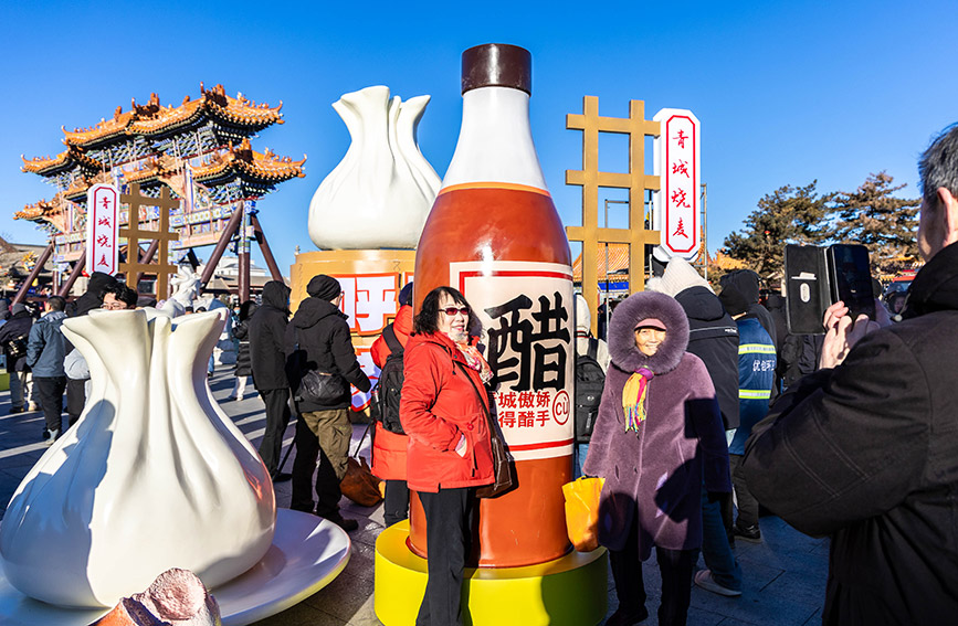 12月21日，游客在呼和浩特?zé)u美食大會(huì)燒賣主題巨型裝置藝術(shù)展上留影。丁根厚攝