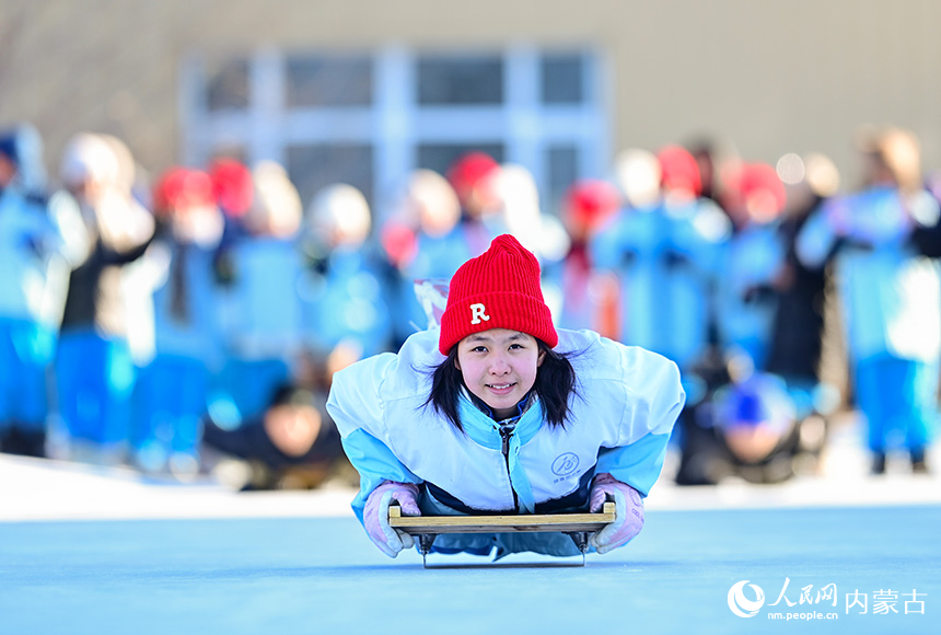 呼倫貝爾市海拉爾區(qū)健康街小學(xué)學(xué)生在校園冰雪嘉年華中參加助跑俯臥式爬犁運動。王正攝