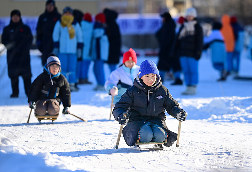 呼倫貝爾市海拉爾區(qū)健康街小學(xué)學(xué)生在校園冰雪嘉年華中參加自助力雙軌爬犁運(yùn)動(dòng)。王正攝