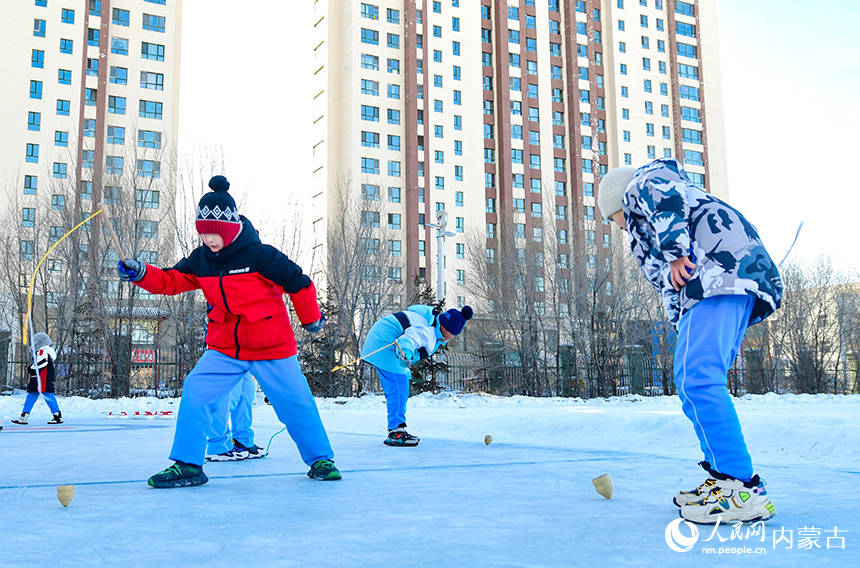 呼倫貝爾市海拉爾區(qū)健康街小學(xué)學(xué)生在校園冰雪嘉年華中參加抽冰尜運(yùn)動(dòng)。王正攝