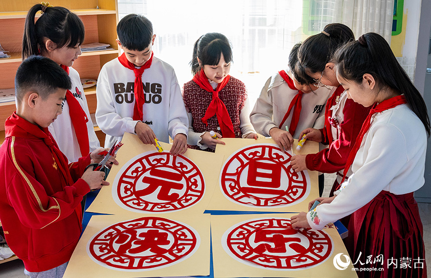 呼和浩特市玉泉區(qū)五塔寺東街小學(xué)學(xué)生在制作慶元旦剪紙作品。丁根厚攝