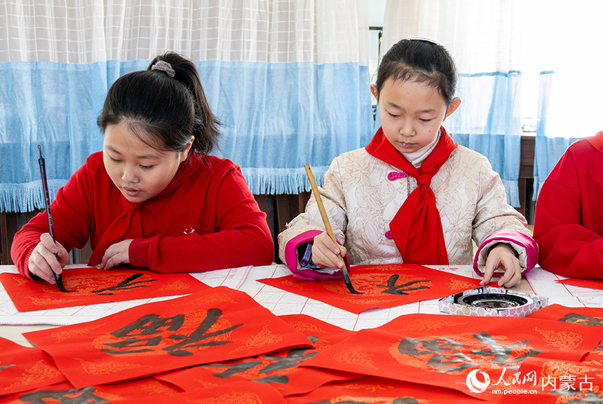 呼和浩特市玉泉區(qū)五塔寺東街小學(xué)學(xué)生在書寫福字。丁根厚攝
