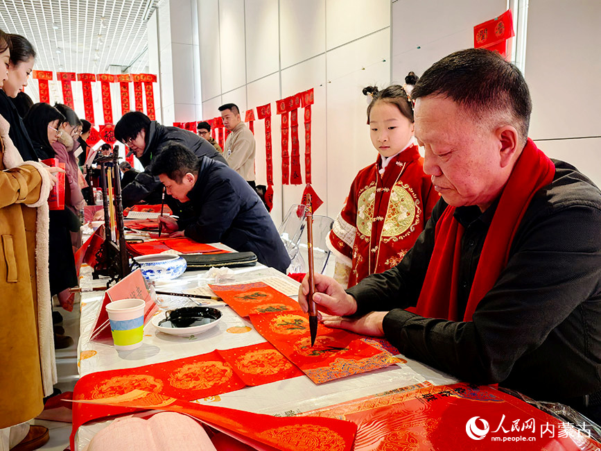 書法愛好者寫春聯(lián)、福字免費(fèi)送給市民，迎接傳統(tǒng)新春佳節(jié)。郝雪嬌攝