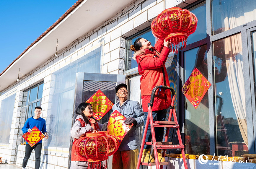 1月18日，志愿者在呼和浩特市玉泉區(qū)“三下鄉(xiāng)”活動(dòng)中入戶為抗美援朝老兵贈(zèng)送新春飾品。丁根厚攝