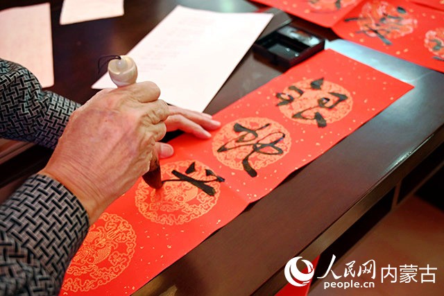 書法愛好者現(xiàn)場書寫春聯(lián)。實習(xí)生 李子薈攝