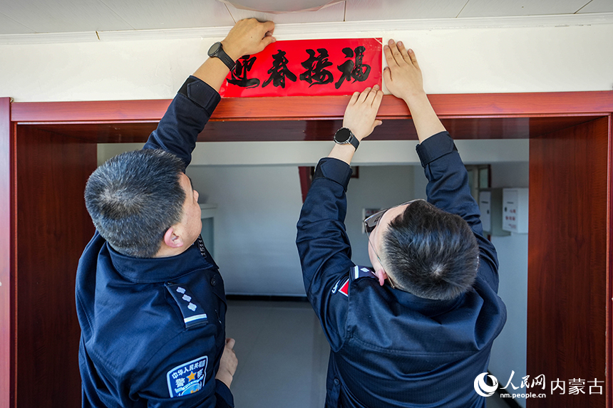二連出入境邊防檢查站移民管理警察張貼對聯(lián)喜迎新春。楊金燁攝