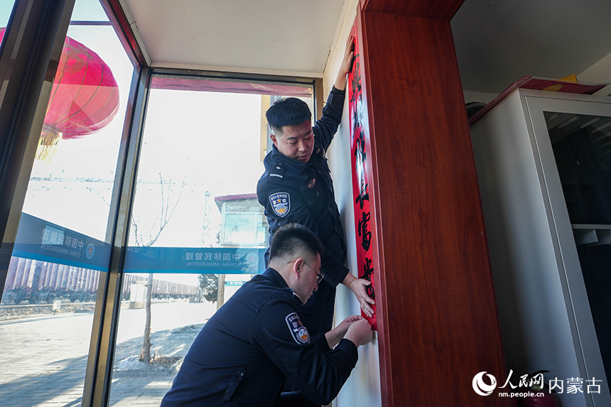二連出入境邊防檢查站移民管理警察在單位張貼對(duì)聯(lián)做著喜迎新春的準(zhǔn)備。楊金燁攝