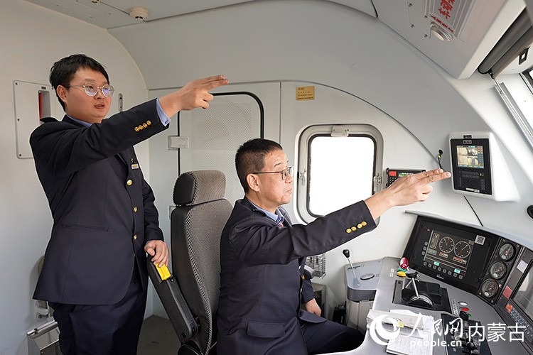 陳鵬與徒弟武斌正在駕駛?cè)f噸列車。王哲輝攝