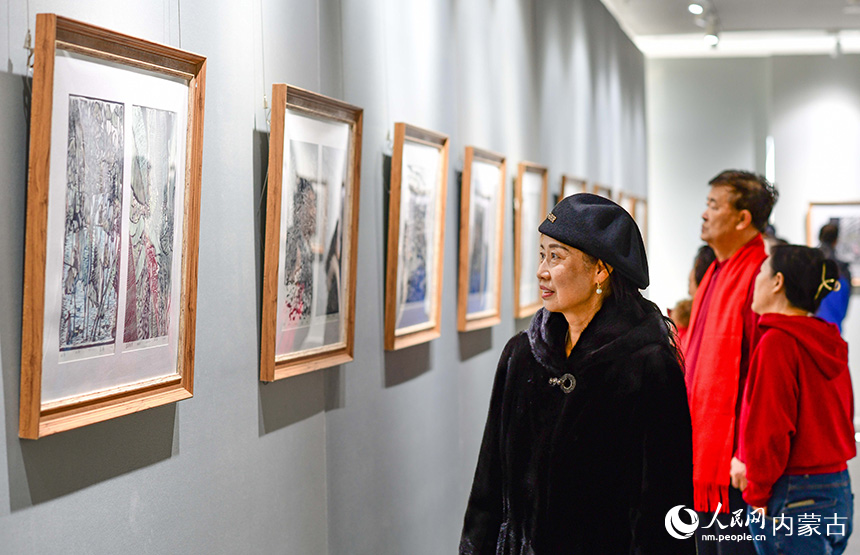觀眾在鄂爾多斯市文化館觀賞陜西安康木板畫展。王正攝