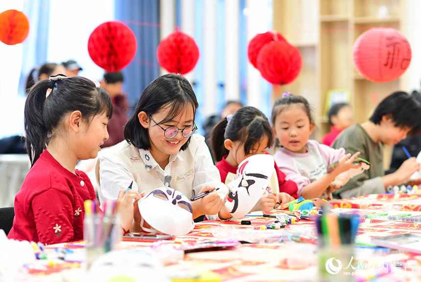 小朋友在康巴什區(qū)園丁社區(qū)畫臉譜。王正攝
