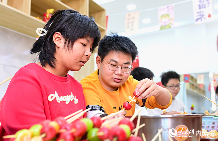 學生在康巴什區(qū)園丁社區(qū)體驗制作冰糖葫蘆。王正攝